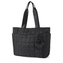 Load image into Gallery viewer, Angled front view of Nollia Emilia black quilted tote bag with heart charm detail