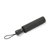 Load image into Gallery viewer, Compact sleeve view – Black umbrella stored inside its protective sleeve with handle exposed.