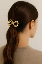 Load image into Gallery viewer, Woman wearing Nollia gold metal bow hair tie in ponytail