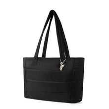 Load image into Gallery viewer, Angled front view of black nylon commuter tote with padded handles and key charm.
