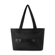 Load image into Gallery viewer, Back view of black quilted commuter tote with luggage strap for travel.
