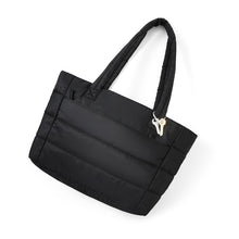 Load image into Gallery viewer, Black commuter tote bag laid flat at an angle with padded straps and key charm.
