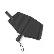 Load image into Gallery viewer, Closed folded view – Black umbrella neatly folded with strap fastened around the canopy.
