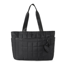 Load image into Gallery viewer, Nollia Emilia black quilted tote bag with padded design and heart bag charm, front view
