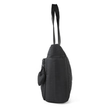 Load image into Gallery viewer, Side profile of Nollia Emilia black quilted tote bag with heart charm and shoulder straps
