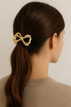 Load image into Gallery viewer, Woman wearing Nollia gold metal bow hair tie in ponytail
